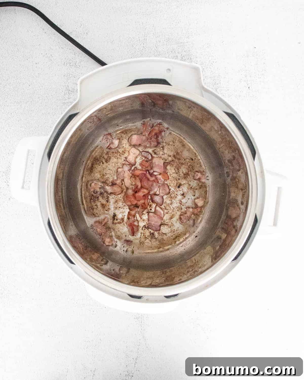 Bacon being sautéed in an instant pot.