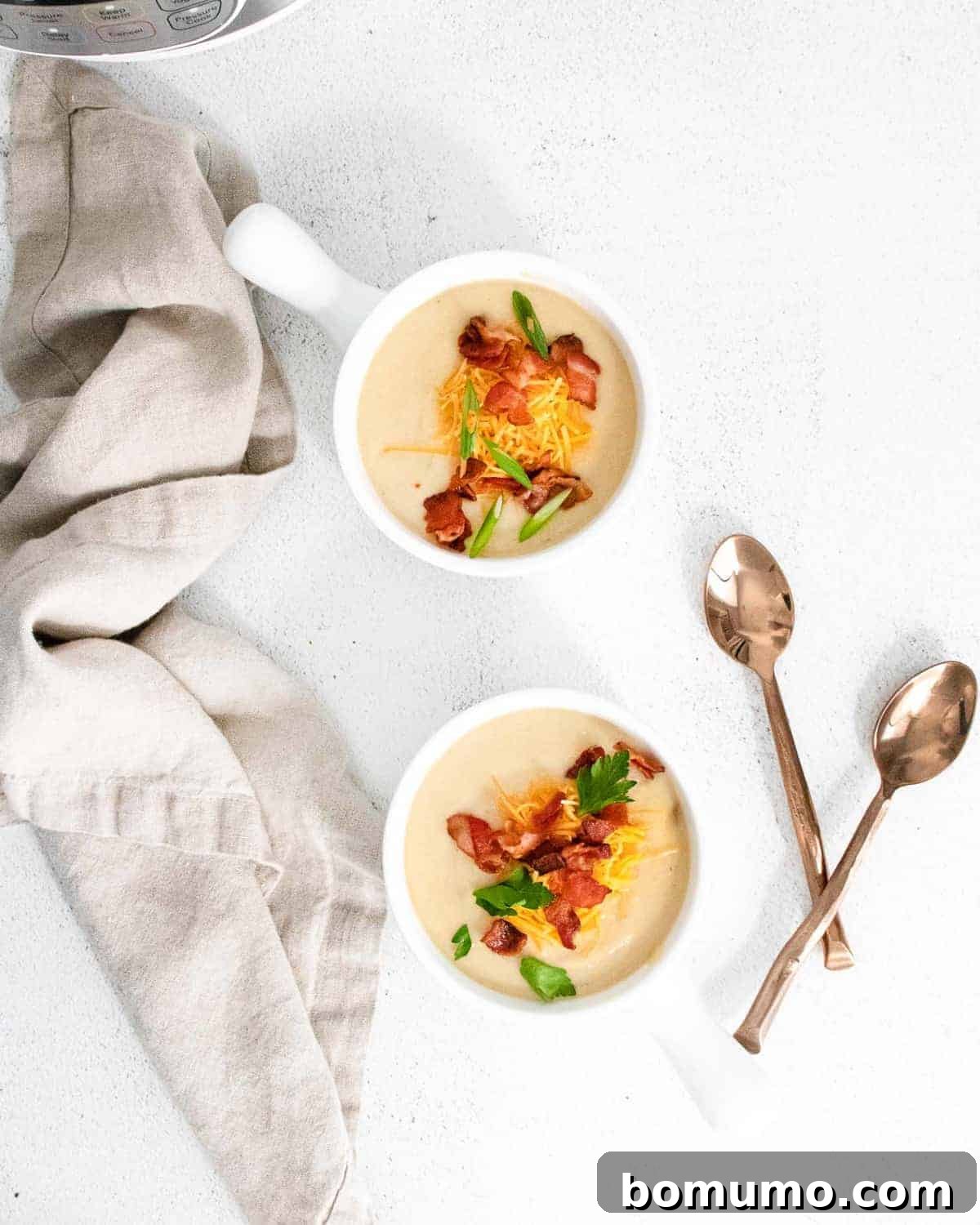 Two bowls of soup and two spoons.
