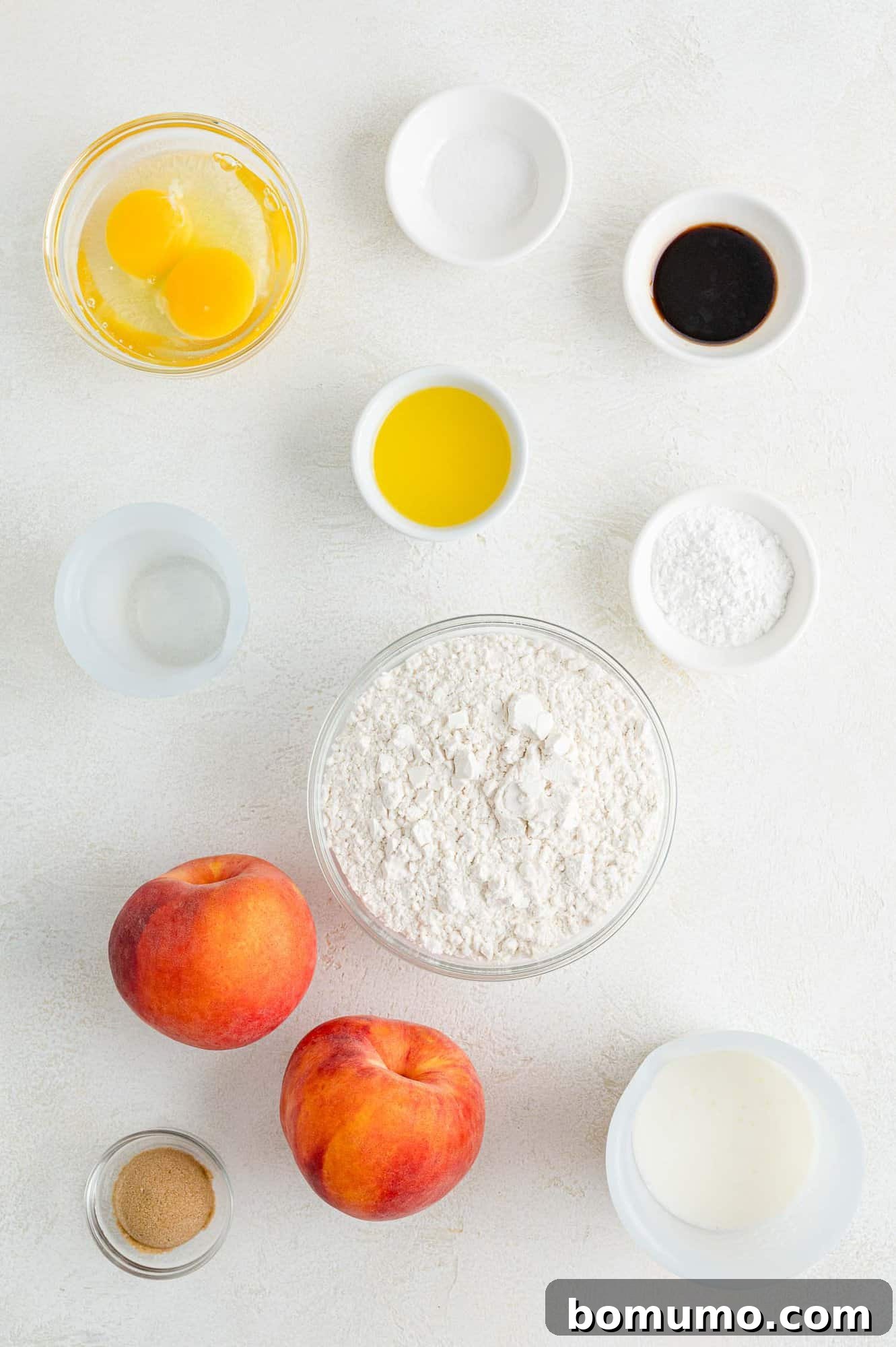 A collection of fresh, ripe ingredients laid out for peach pancakes, including whole peaches, eggs, and butter, setting the stage for cooking.
