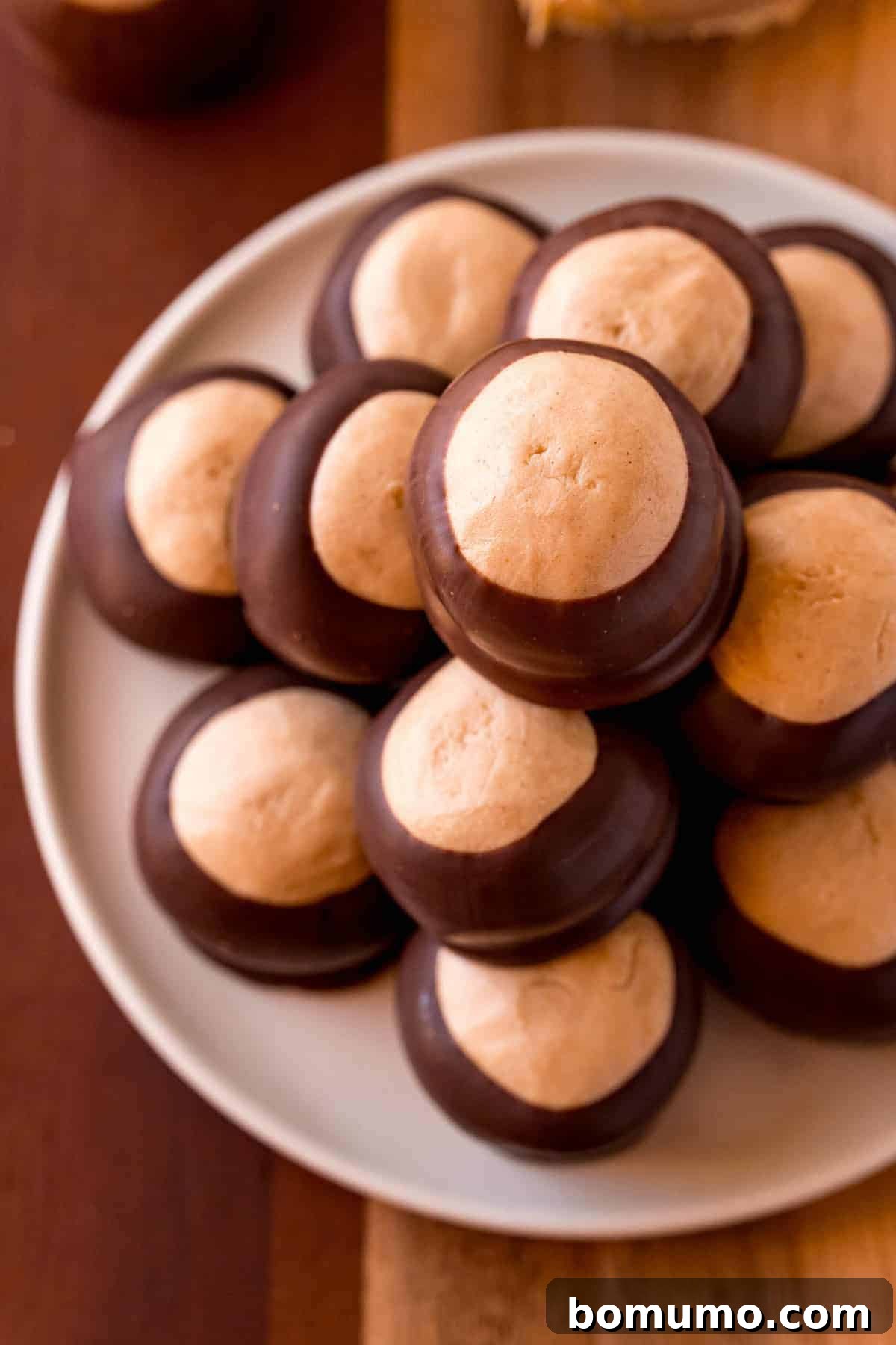 A beautifully arranged pile of buckeyes candy on a rustic wooden plate, ready to be enjoyed.