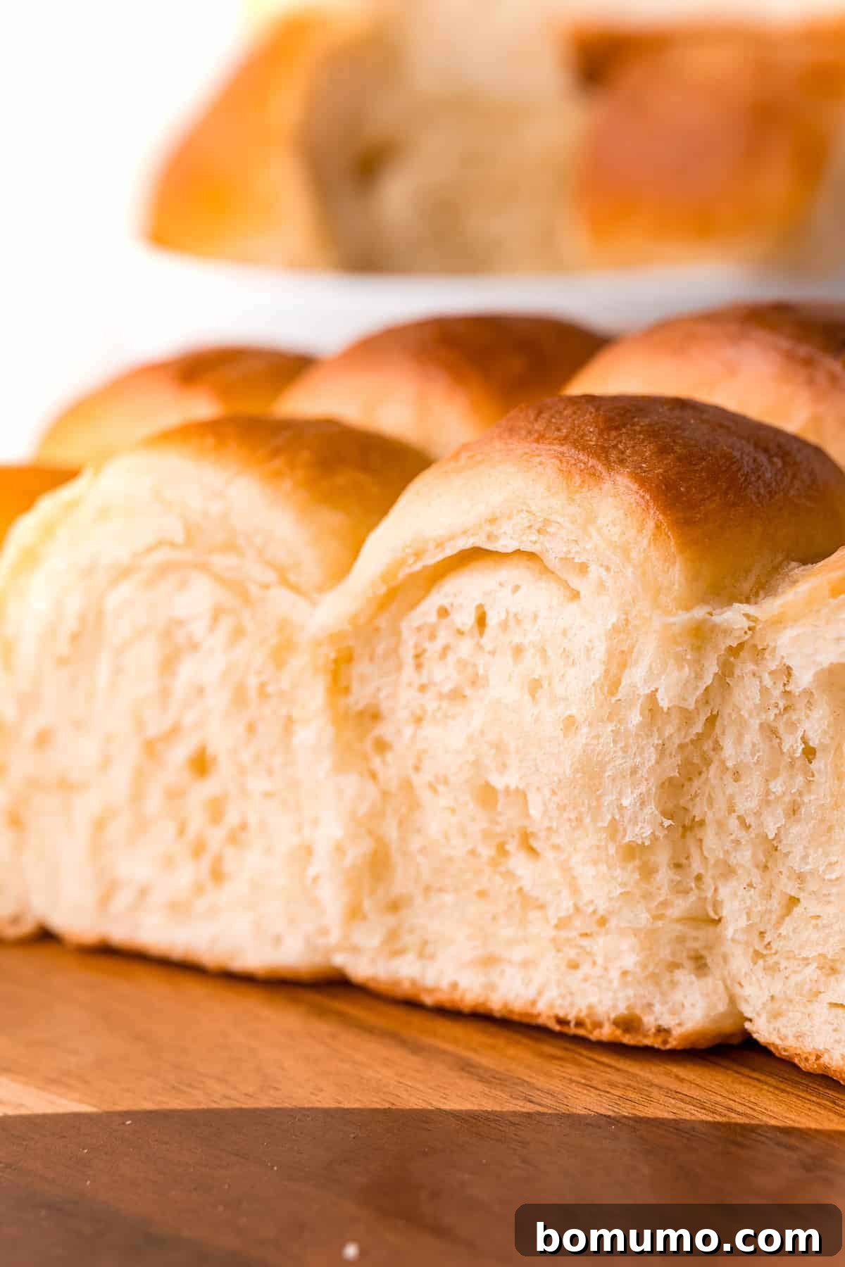 A curated display of fluffy dinner rolls arranged elegantly on a wooden surface, ready for serving.