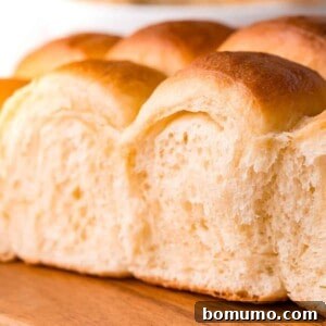 Close up soft fluffy parker house rolls on a wooden board.