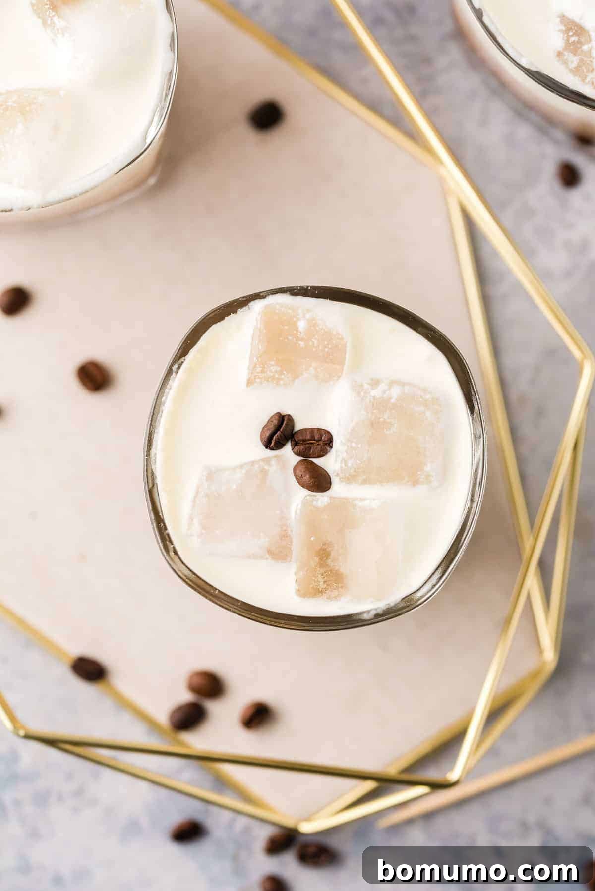 Overhead view of a drink on ice, garnished with coffee beans.