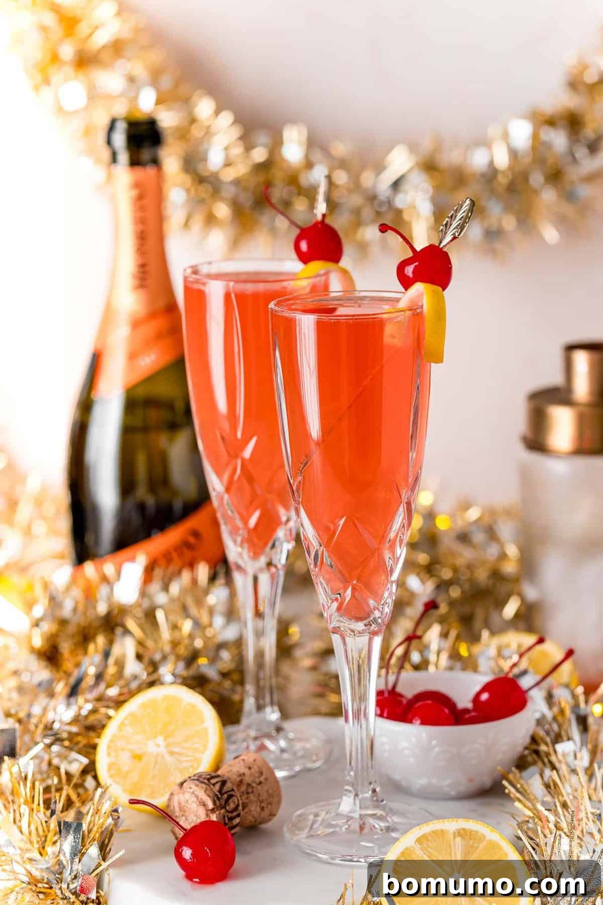 Two champagne glasses full of cherry french 75 cocktail.