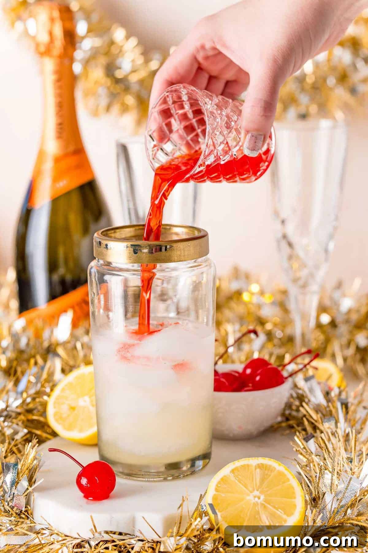 Cherry juice being poured into a cocktail shaker.