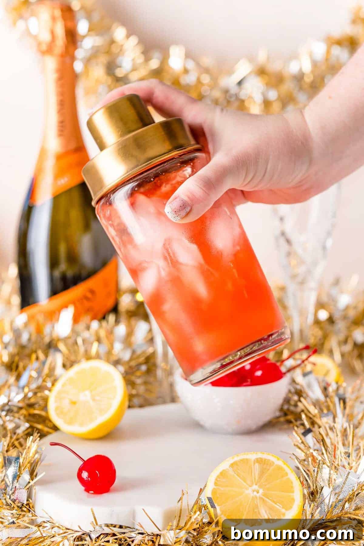 Cocktail shaker full of light red liquid.