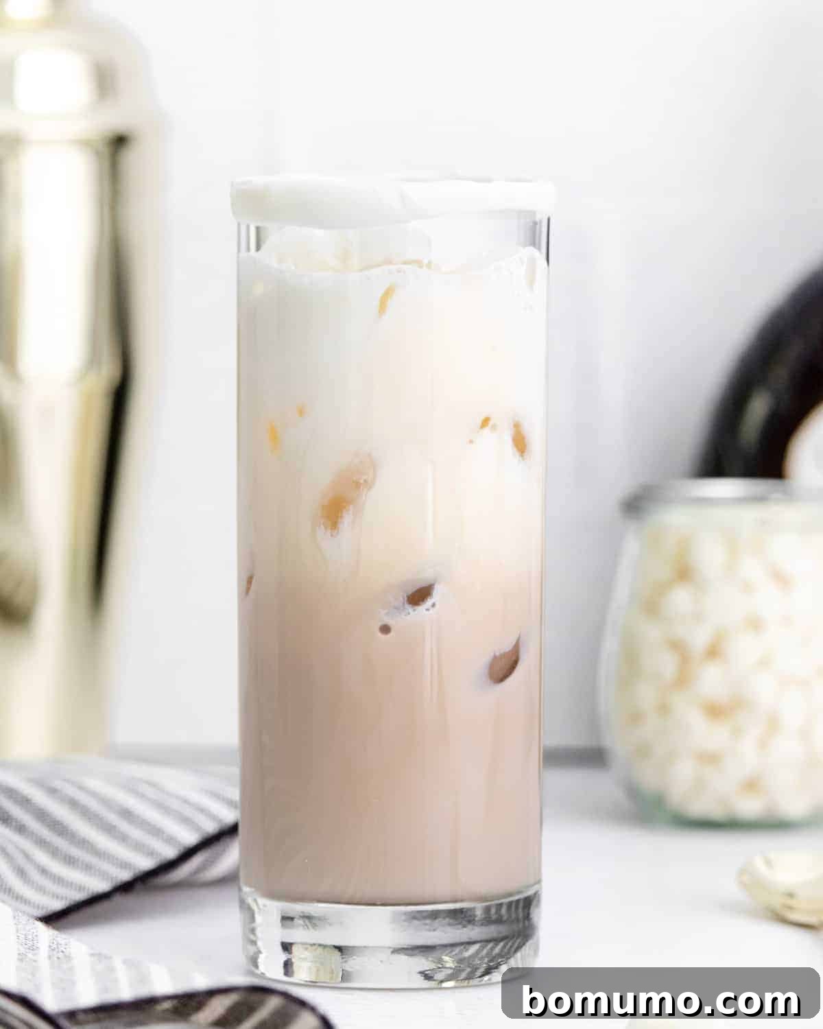 A sophisticated White Chocolate White Russian cocktail with distinct layers of light brown, creamy white, and ice, ready to be enjoyed.