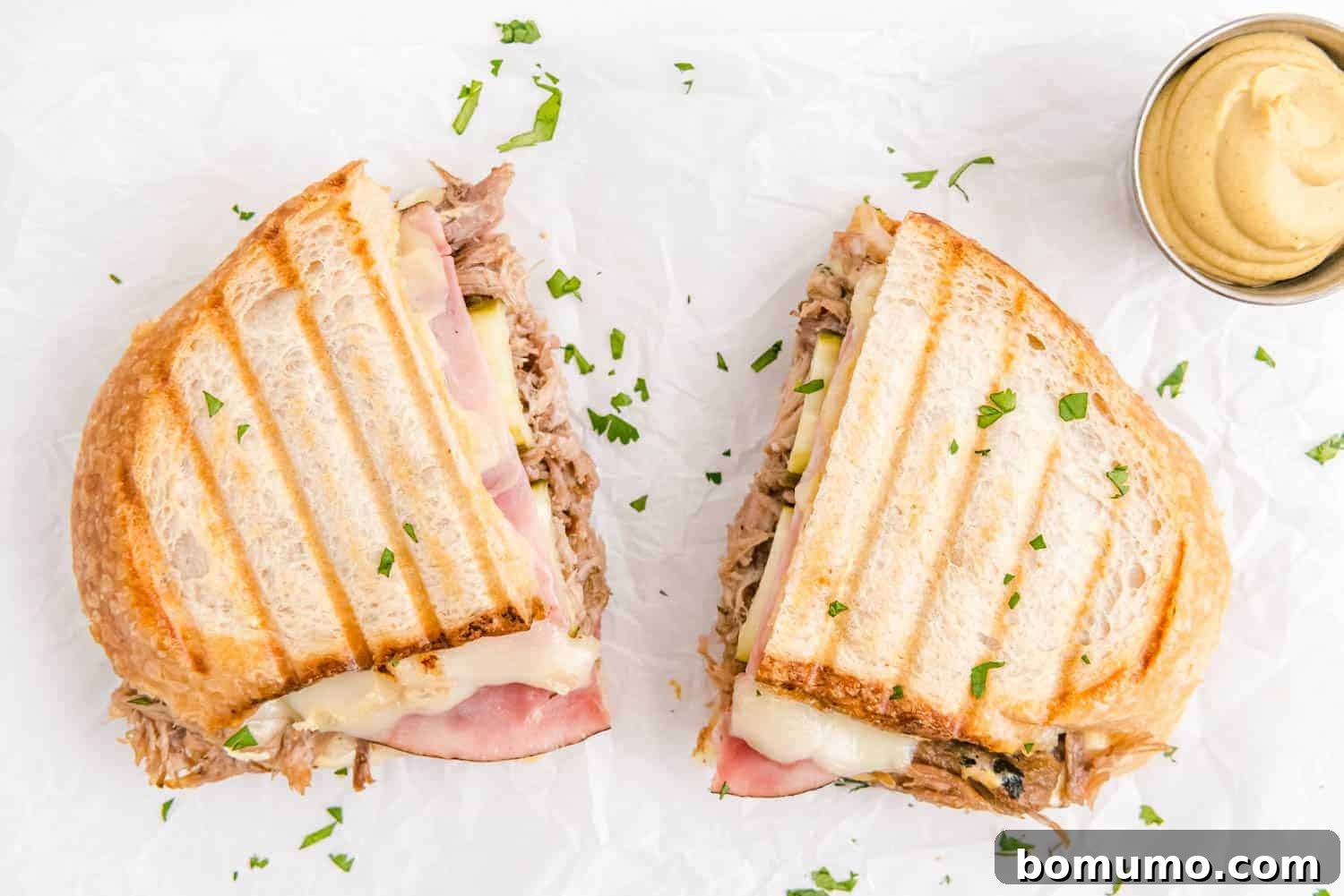 Ultimate Cuban Sandwich 10 A delicious Cuban sandwich, perfectly grilled and neatly split into two halves, ready to be enjoyed.