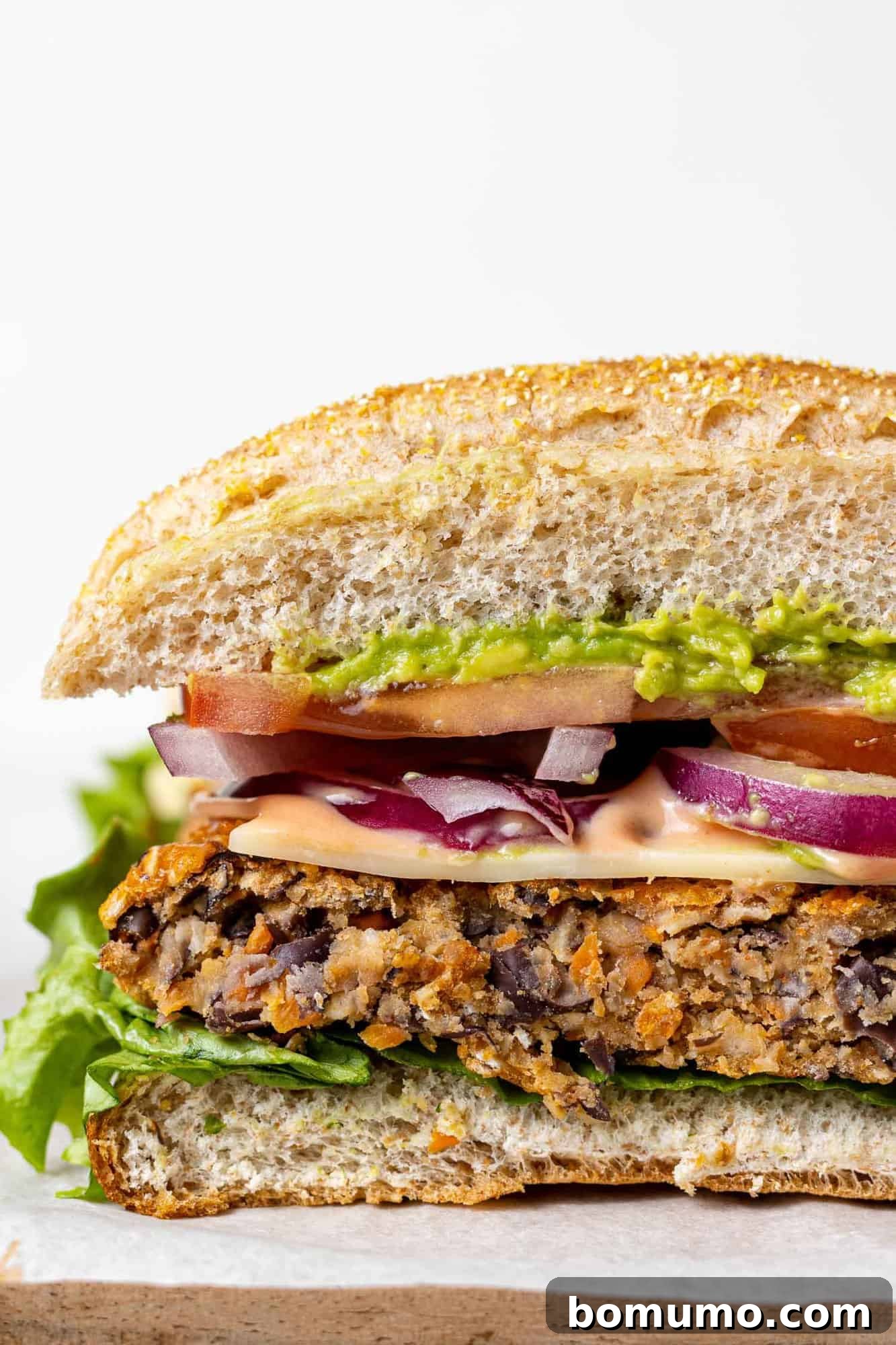 Savory Black Bean Bliss 14 A delicious black bean burger with fresh toppings, sliced to showcase its firm and appealing internal texture.