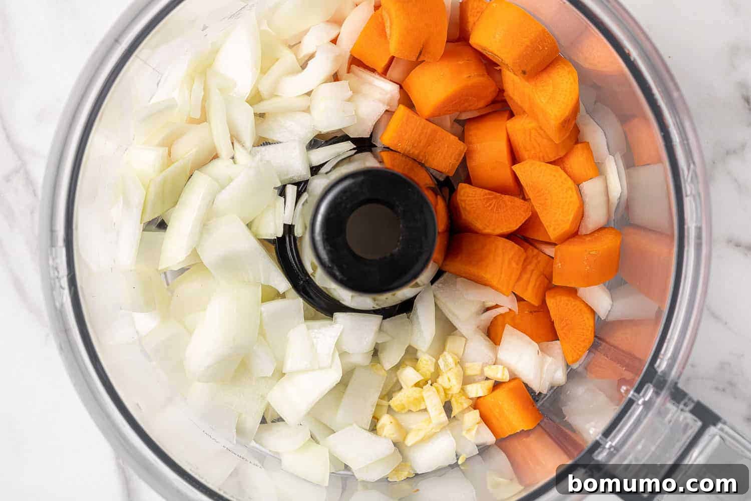 Savory Black Bean Bliss 6 Roughly chopped onions, carrots, and garlic expertly placed in a food processor, poised to be pulsed into fine pieces for the black bean burger mixture.