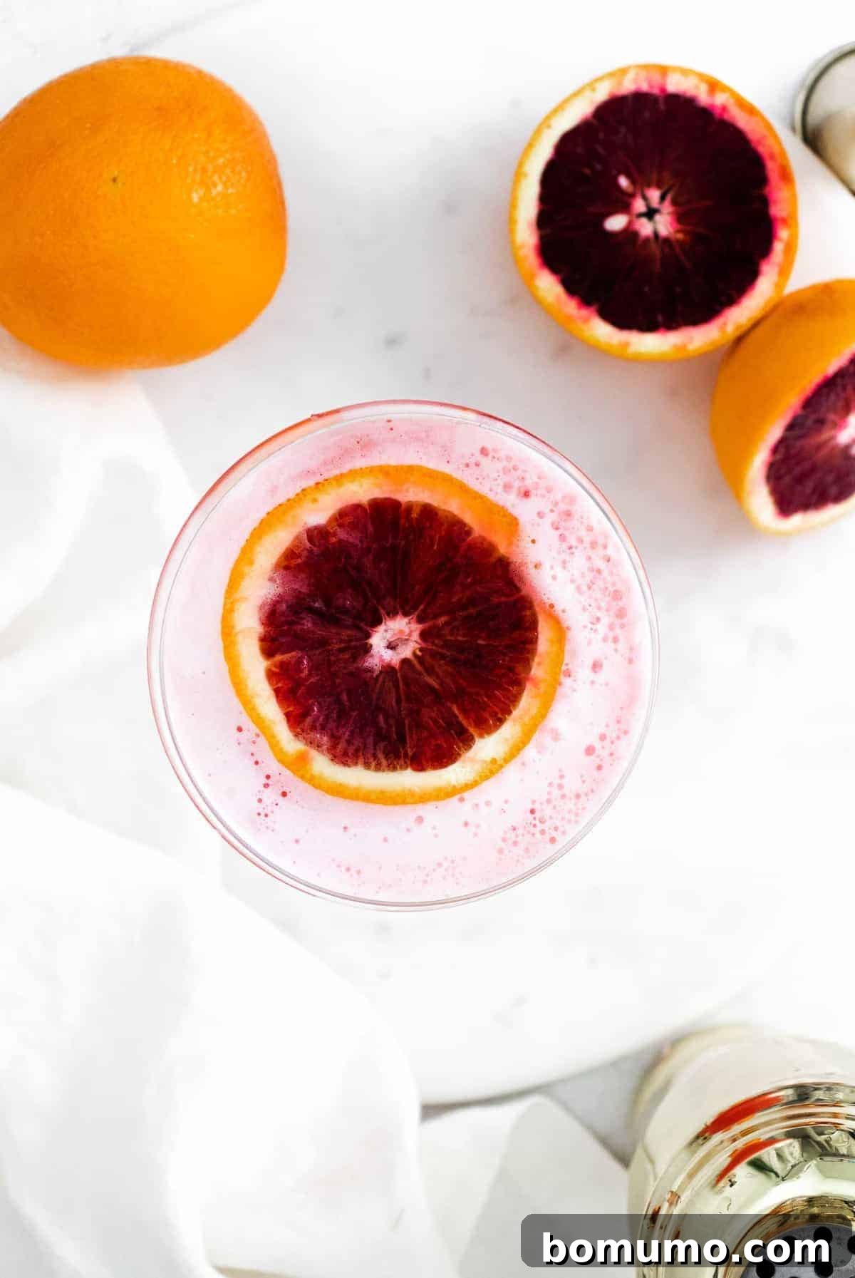 Overhead view of a drink with a slice of blood orange floating in it. A stunning Blood Orange Gin Fizz.
