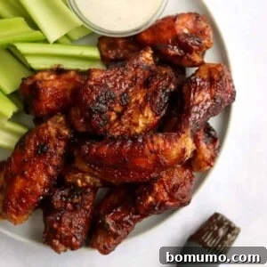 Air fryer barbecue chicken wings on a plate with celery and dip.