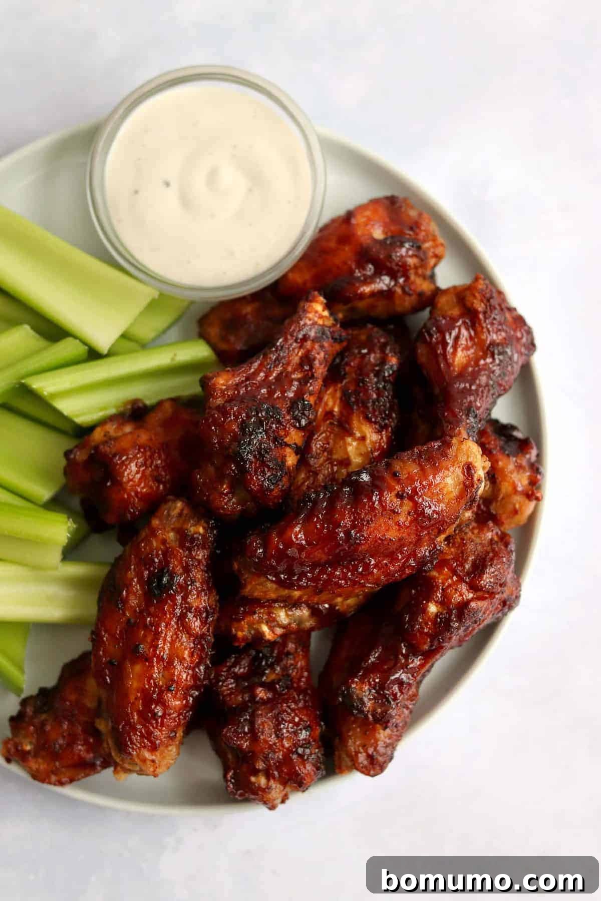 Chicken wings on a plate with celery and ranch.