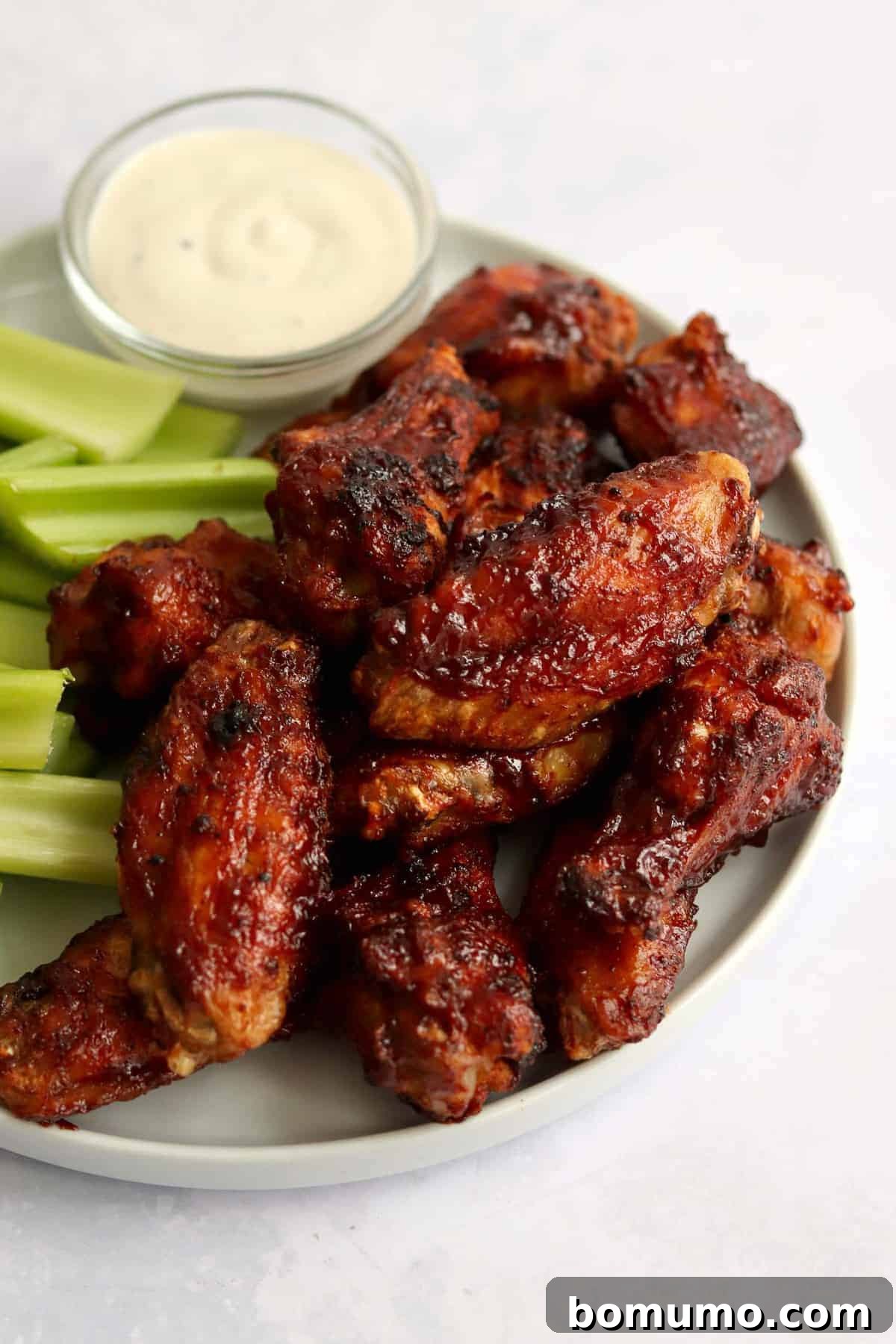 Wings piled up on a plate.