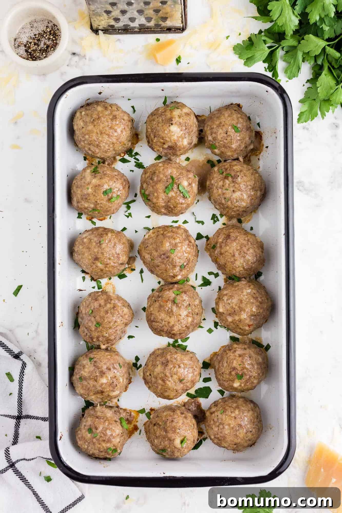 A baking dish filled with beautifully cooked, golden-brown meatballs fresh from the oven.