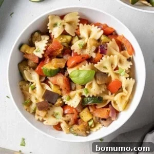Bowl of pasta salad with bowtie pasta and grilled vegetables.