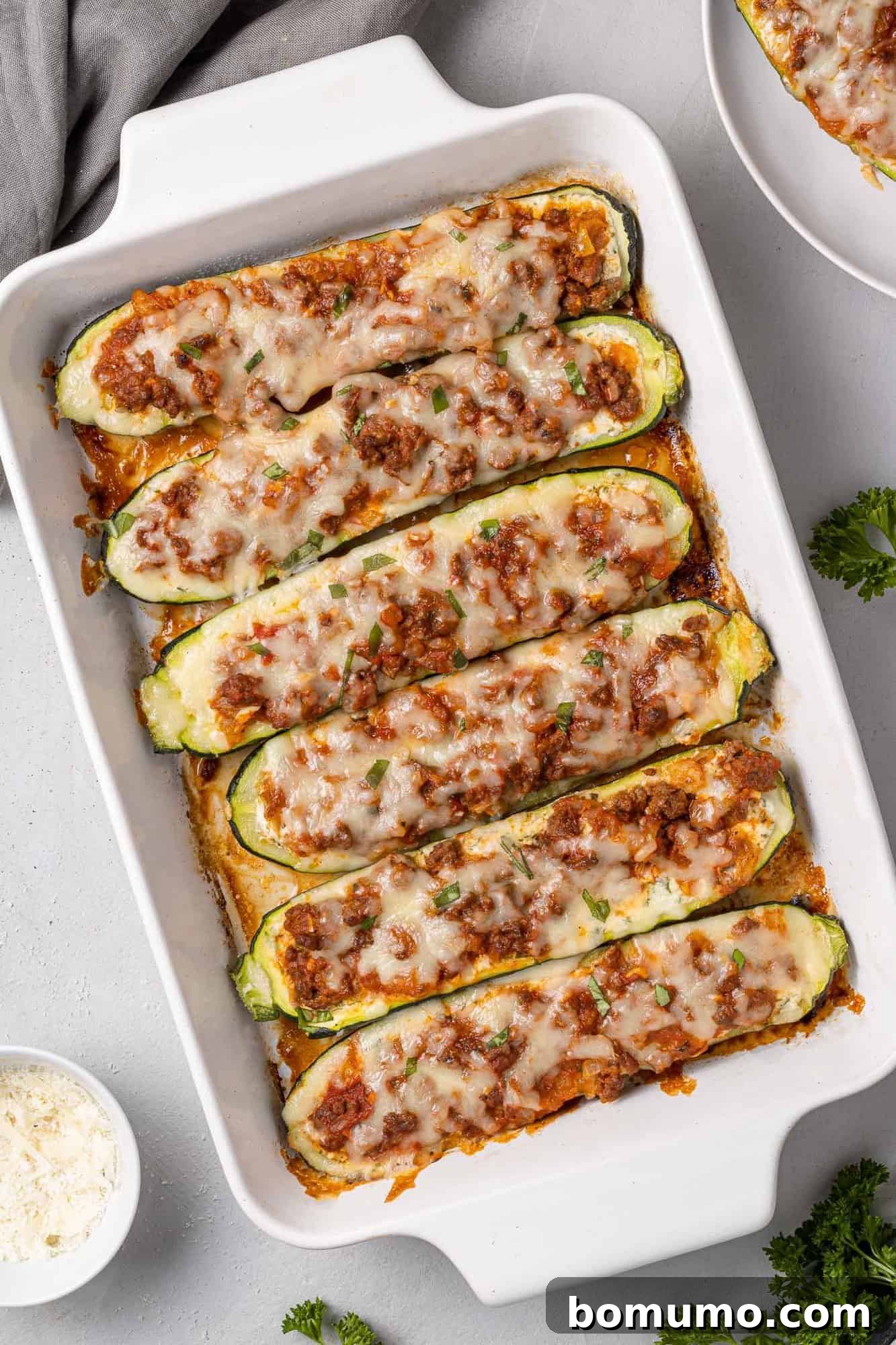 White baking dish with stuffed lasagna halves.