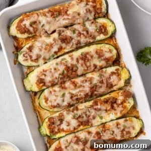 Lasagna boats in a white baking dish, filled with ricotta and meat sauce.
