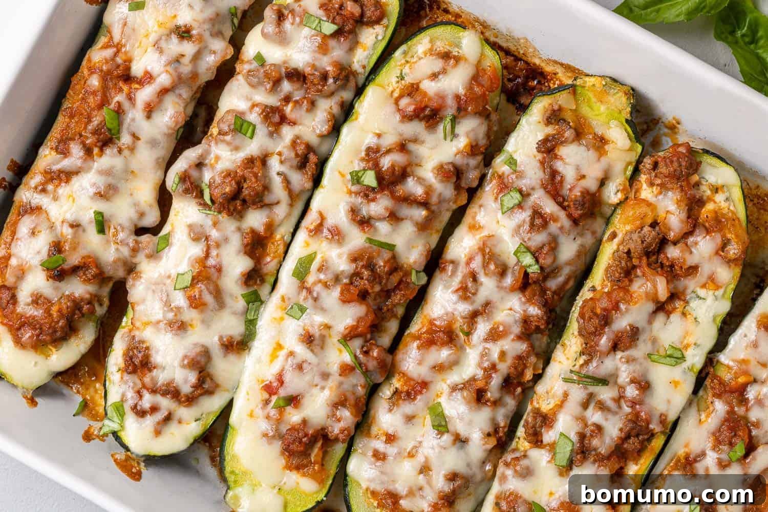 Stuffed zucchini topped with meat sauce and cheese.