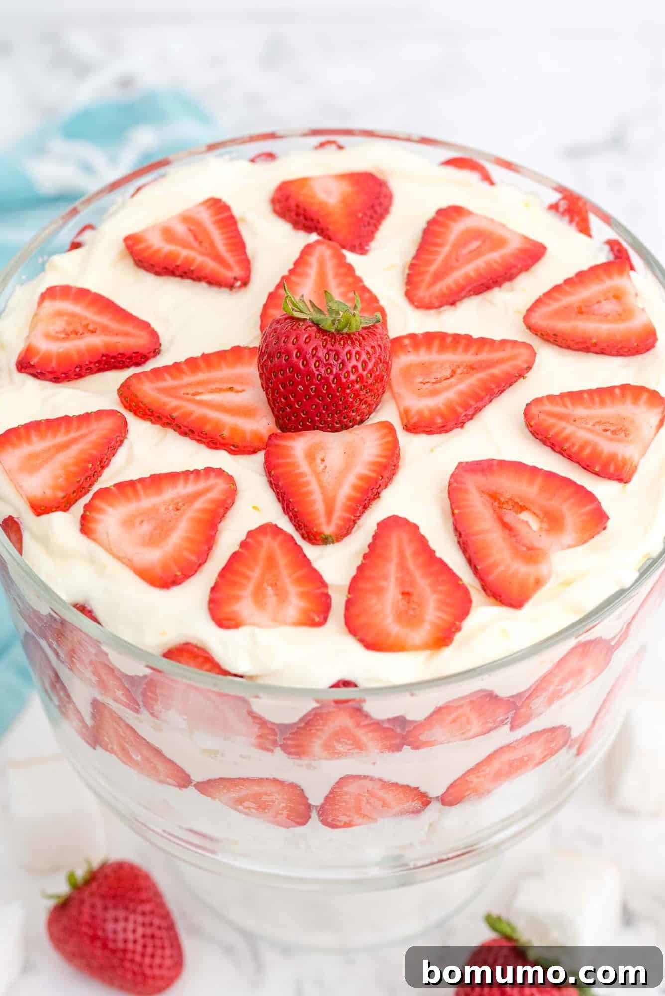 Effortless Strawberry Trifle 14 Strawberry trifle, artfully garnished with fresh strawberries on top, captured from a top-down perspective.