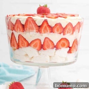 Layered strawberry trifle in a clear glass trifle bowl.