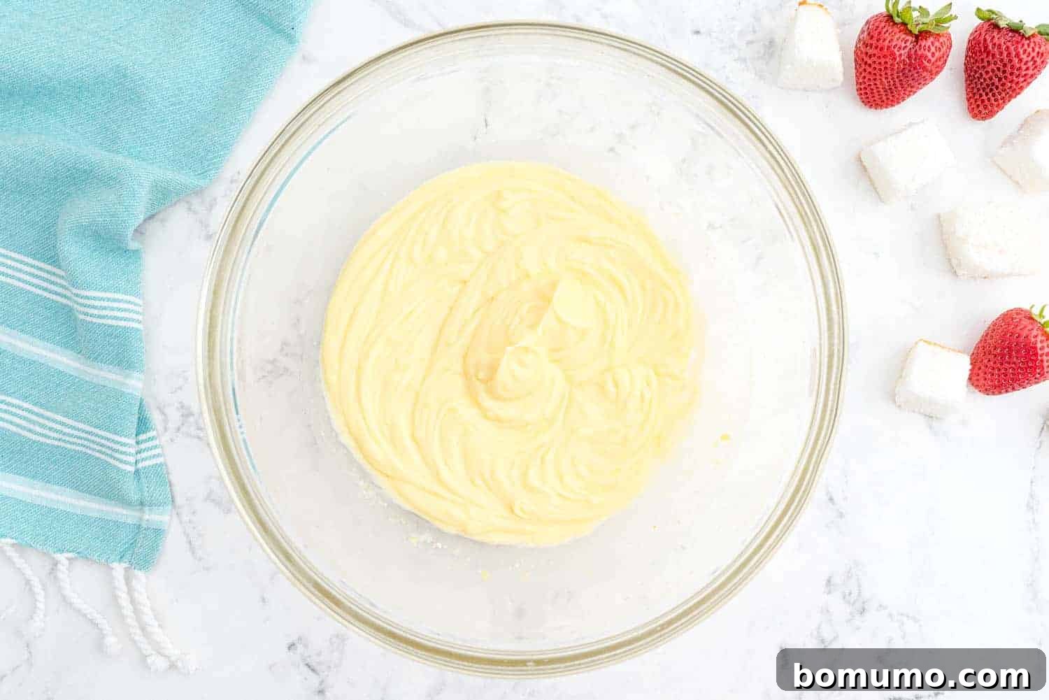 Effortless Strawberry Trifle 8 Smooth and thickened vanilla pudding mixture in a clear glass mixing bowl, ready for the next step.