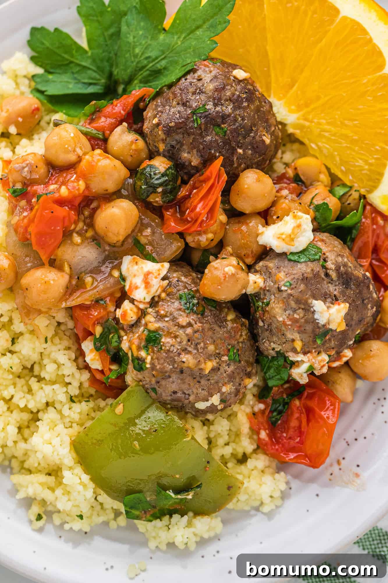 Close-up view of richly spiced Moroccan meatballs served over fluffy couscous.