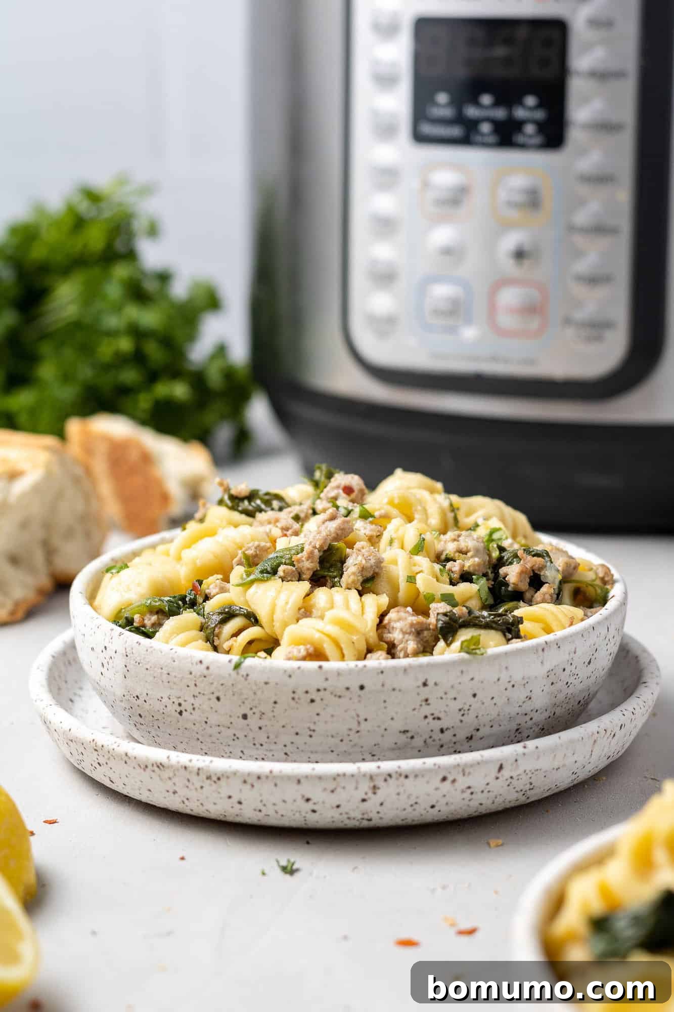 Bowl of instant pot lemon pasta with an instant pot in background.