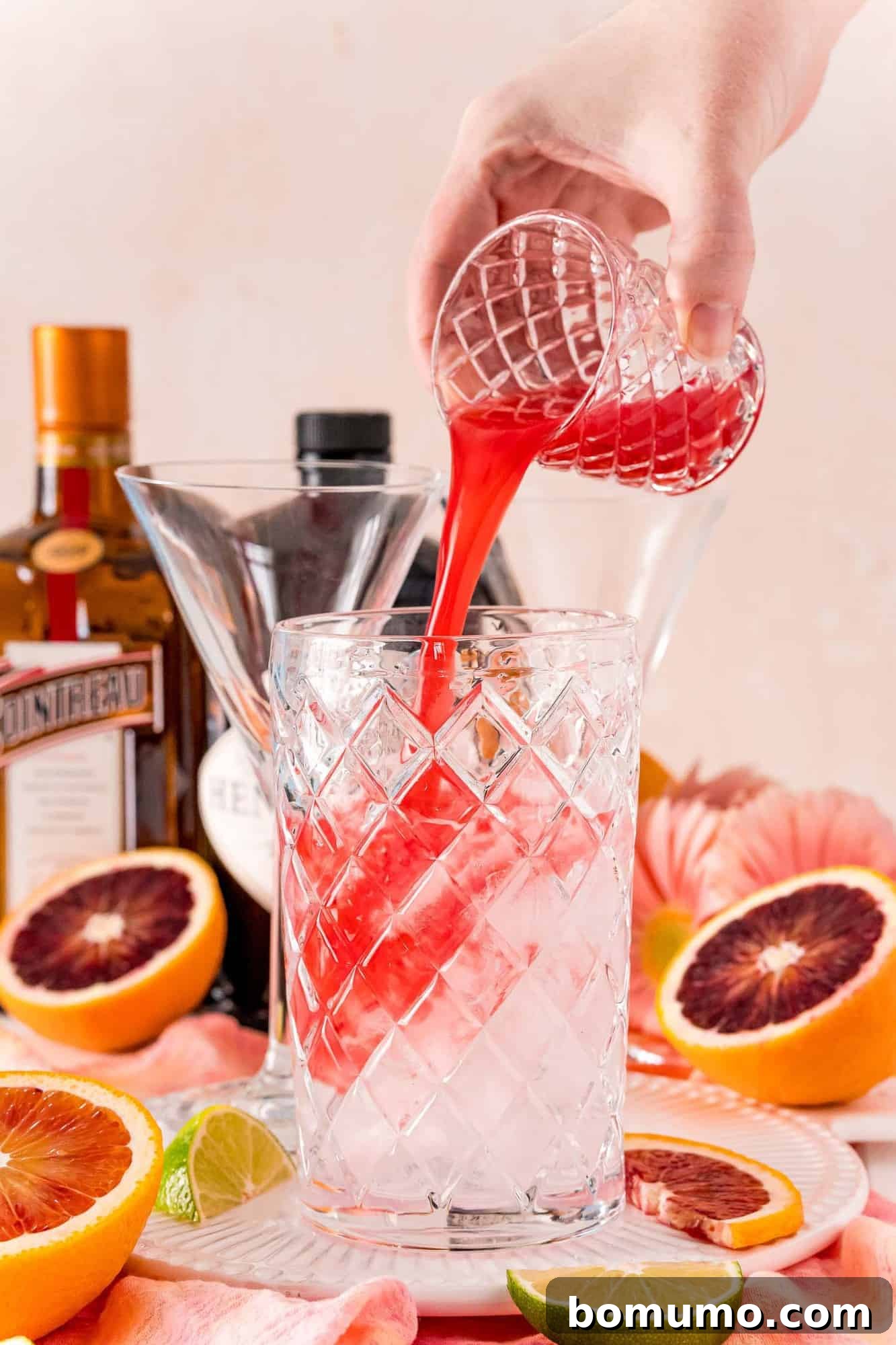 Blood Moon Martini 4 Rich blood orange juice being meticulously poured into a cocktail shaker, ready for mixing.