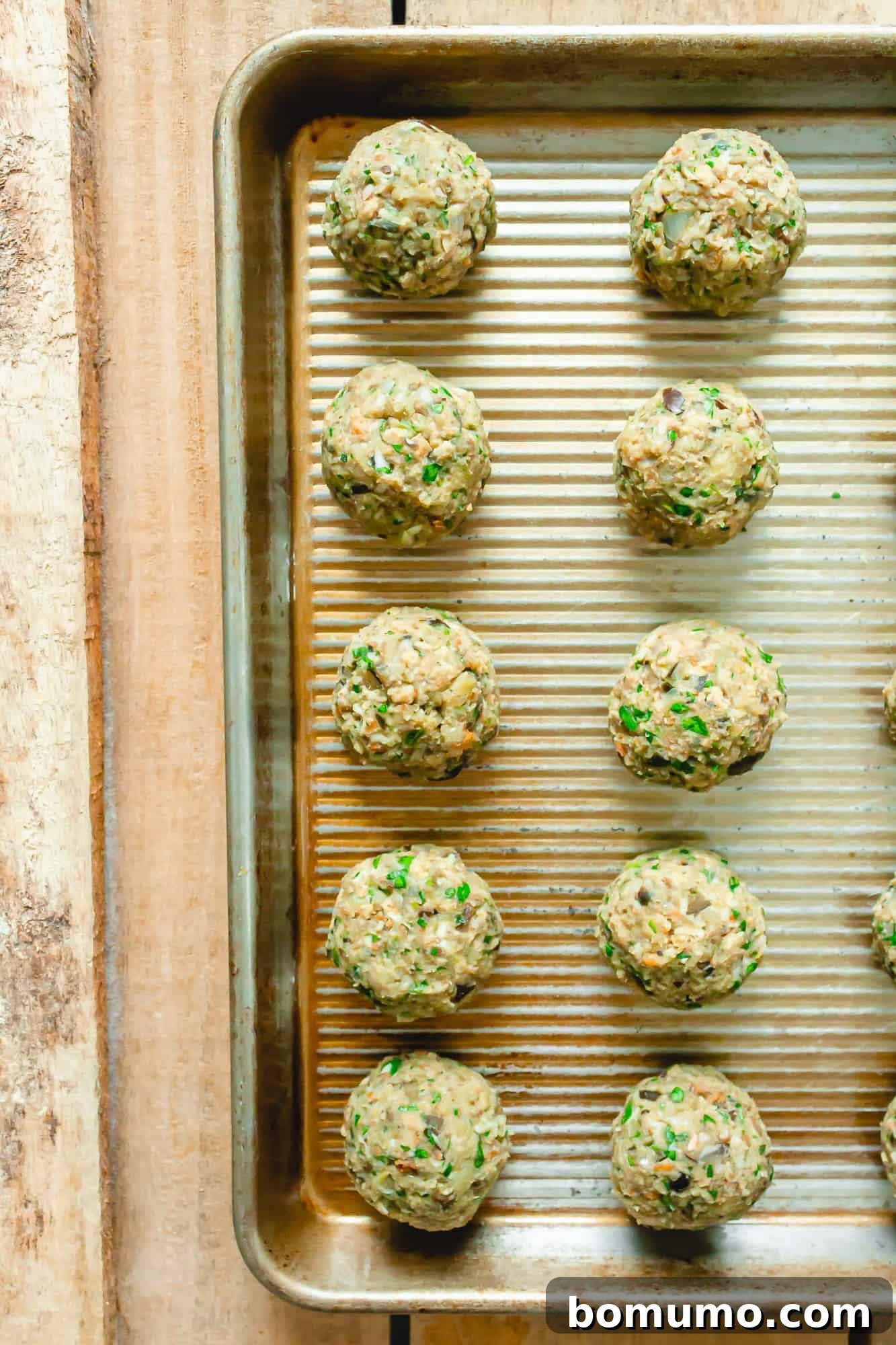 Uncooked vegetarian meatballs on a baking sheet.
