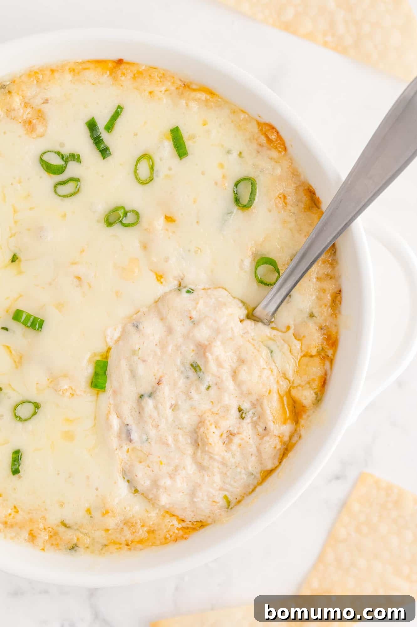 Crab rangoon dip with spoon to show texture.