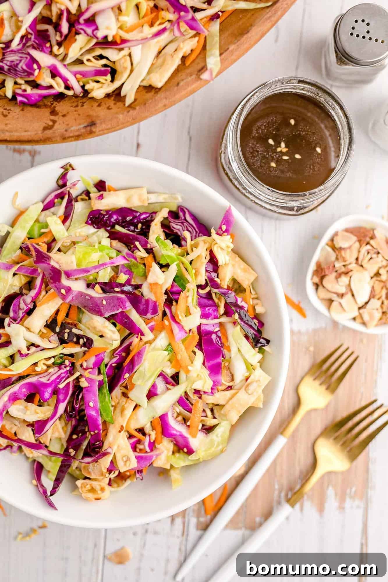 Salad in a white bowl with two forks nearby, inviting you to dig in and enjoy the fresh flavors.