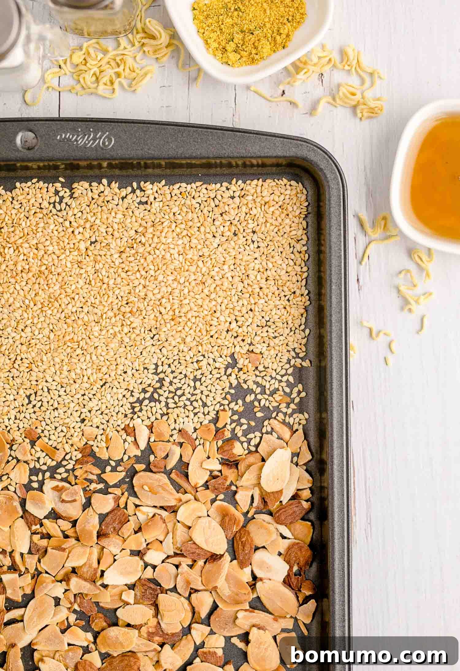 Toasted almonds and sesame seeds on a sheet pan, ready to be added to the salad for extra crunch.