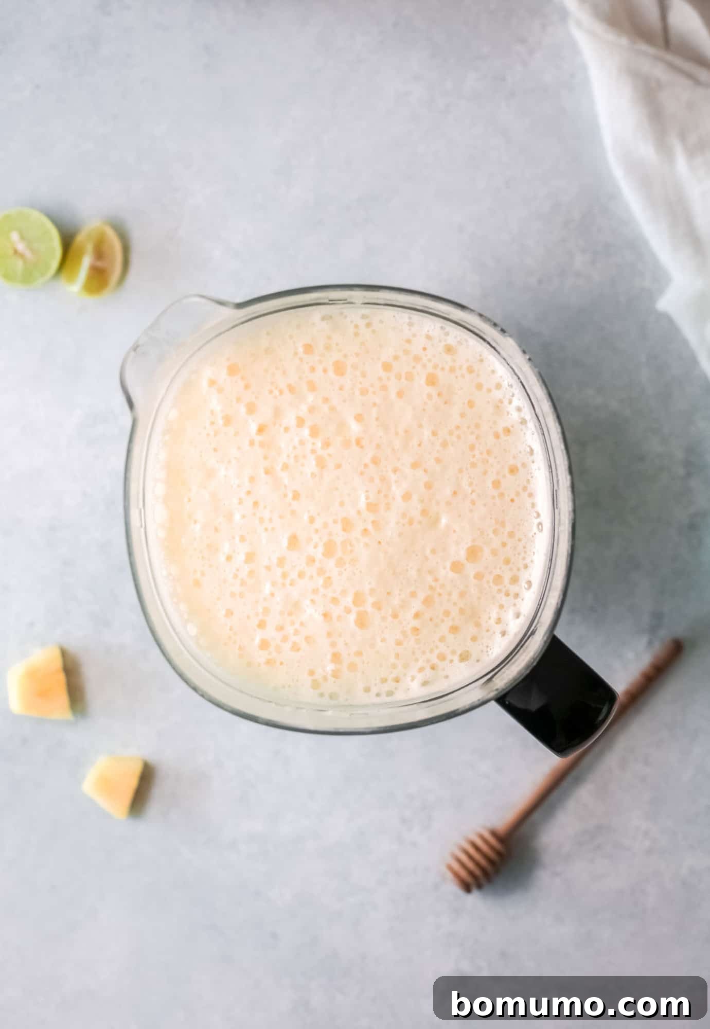 Pineapple Agua Fresca 5 Overhead view of pureed pineapple and water in a blender, showing a smooth, frothy texture.
