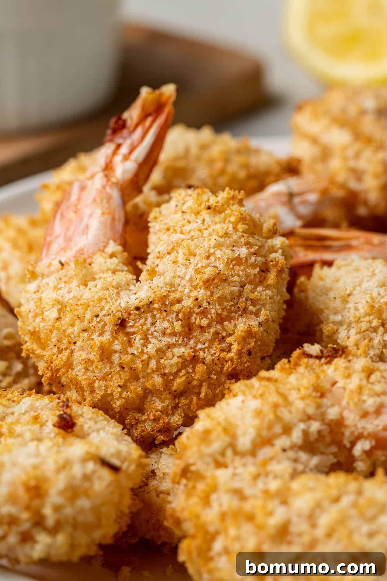 A close-up view of perfectly cooked air fryer breaded shrimp, highlighting the crisp, golden coating and succulent texture.