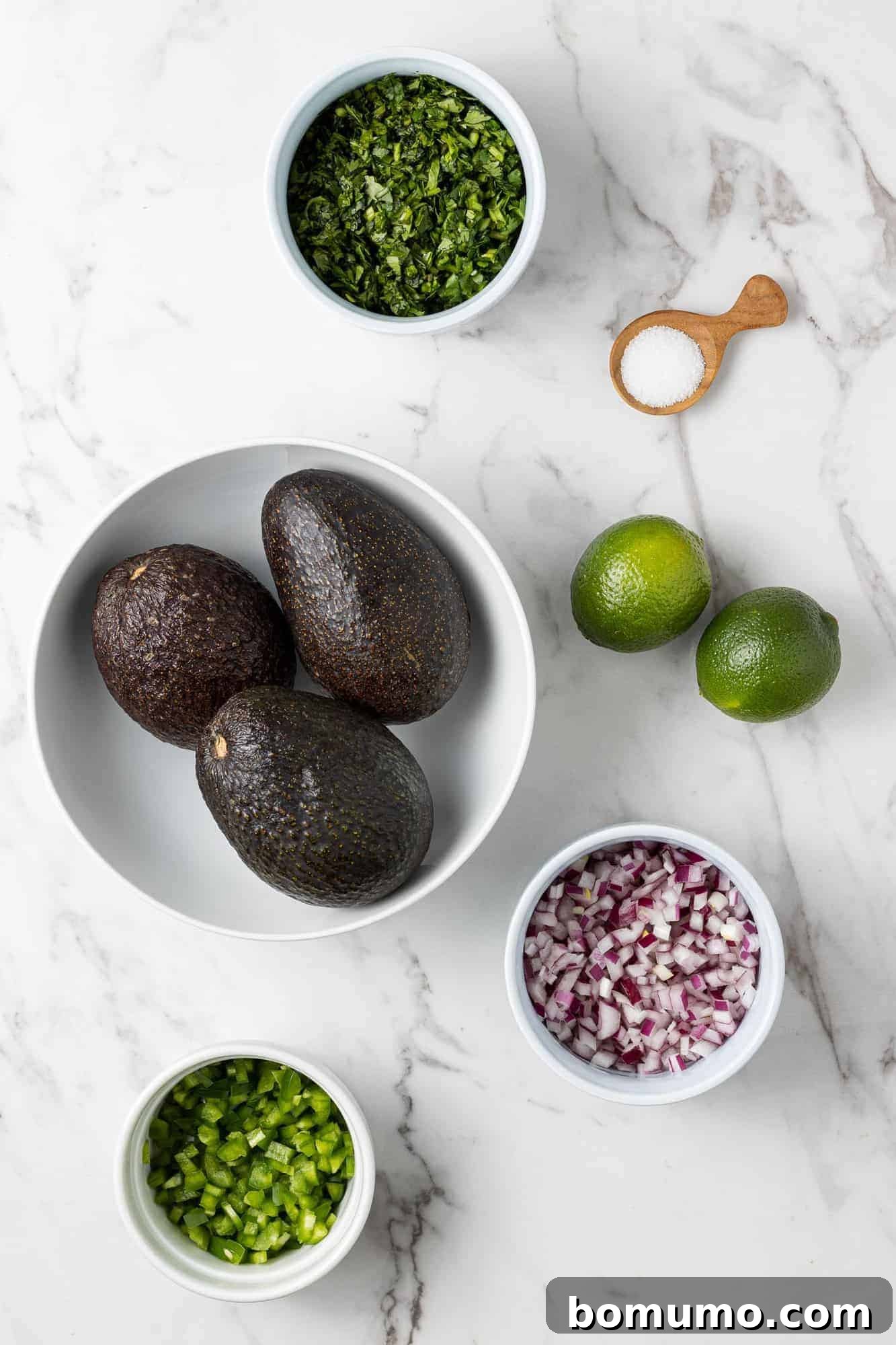 Crafting Perfect Guacamole 4 Overhead view of fresh ingredients: diced jalapeño, vibrant cilantro, halved limes, and kosher salt.