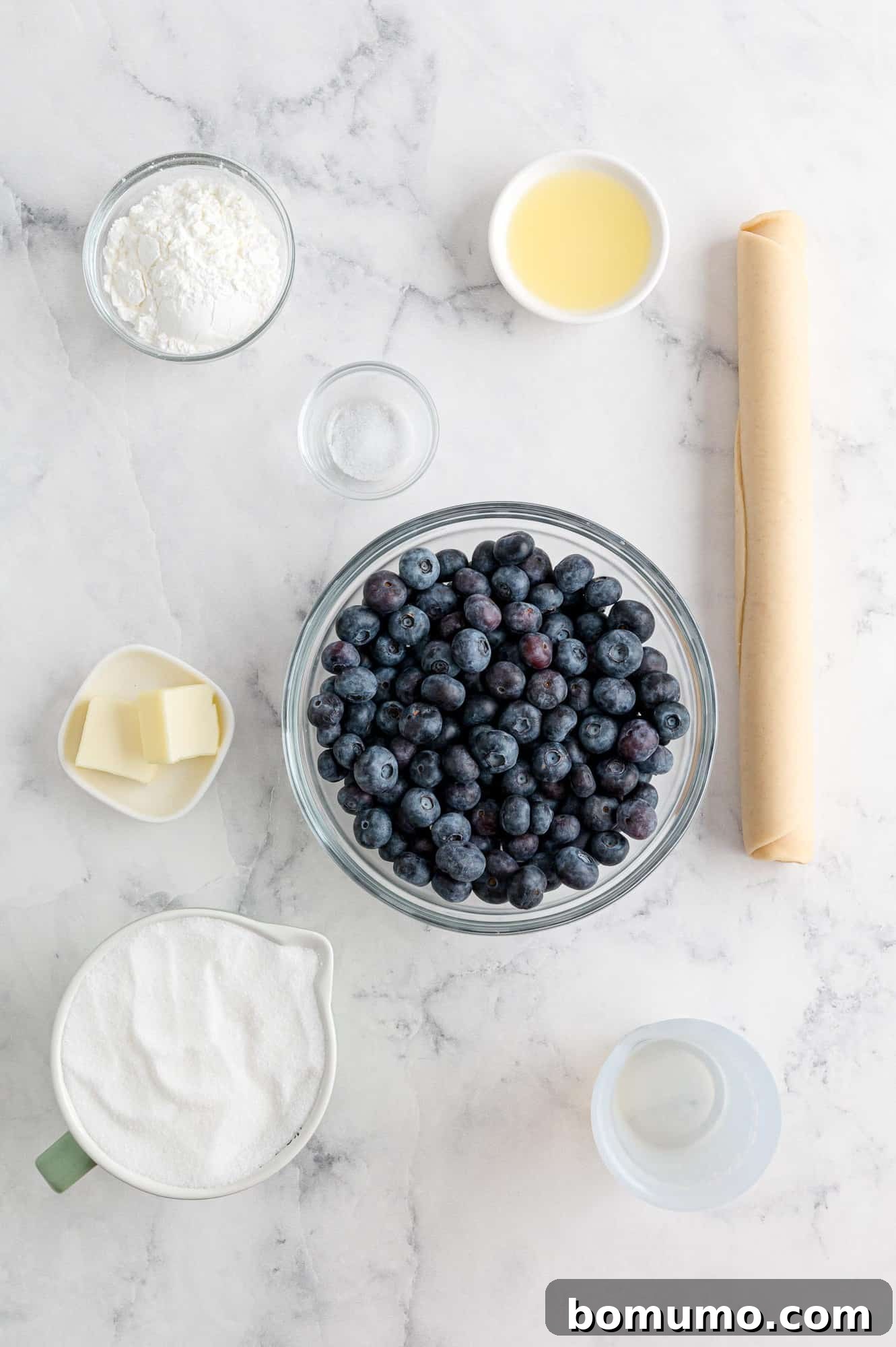fresh-blueberry-pie Ingredients in separate bowls, including fresh blueberries.