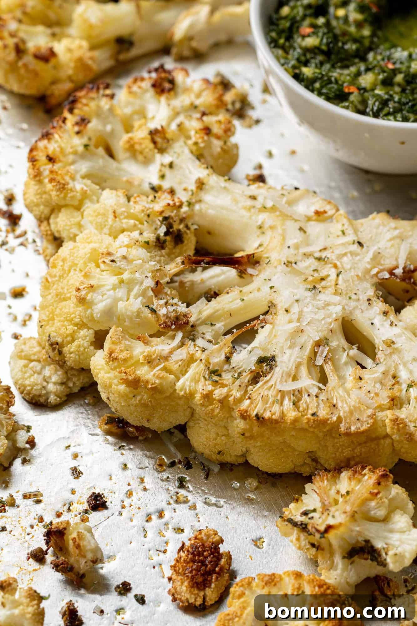 A close-up view of a thick, perfectly roasted cauliflower slice, showcasing its tender texture and golden-brown edges.