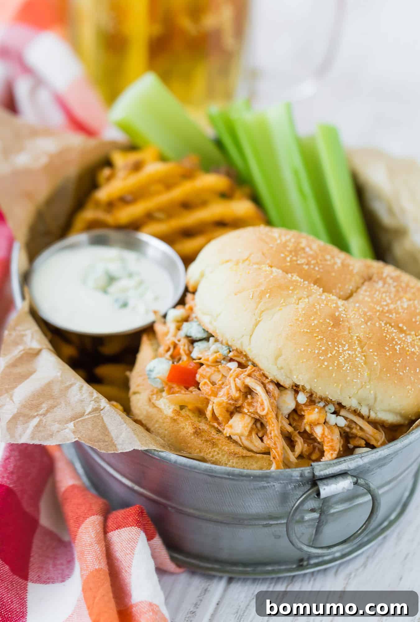 Crockpot buffalo chicken sandwich with fries and celery.