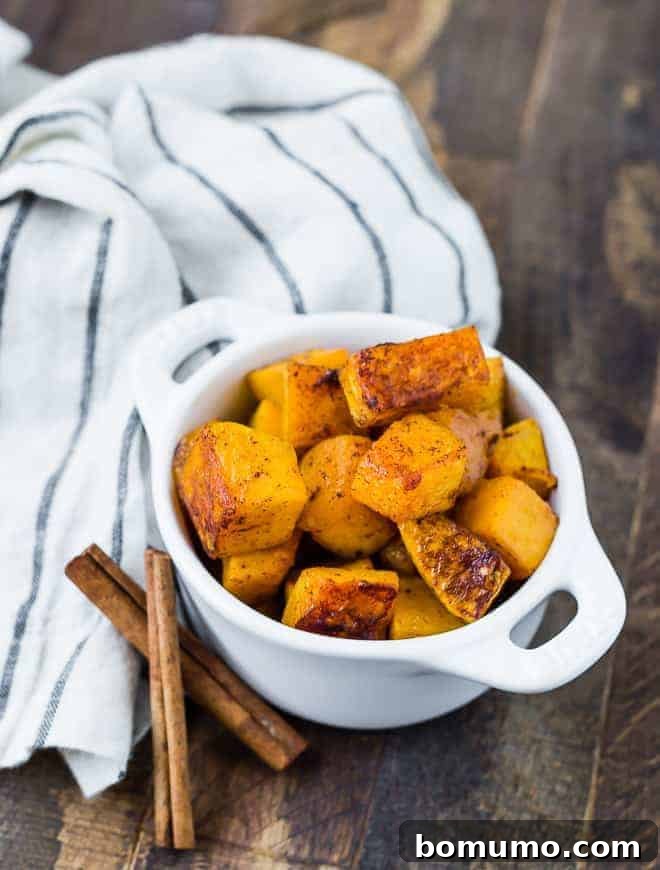 A serving of spicy sweet roasted butternut squash in a small white bowl, ready to be enjoyed.