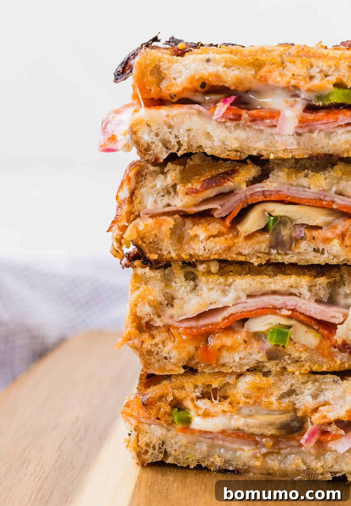 Grilled Pizza Panini 3 Close-up view of pizza panini halves stacked, showcasing the layers of ingredients.