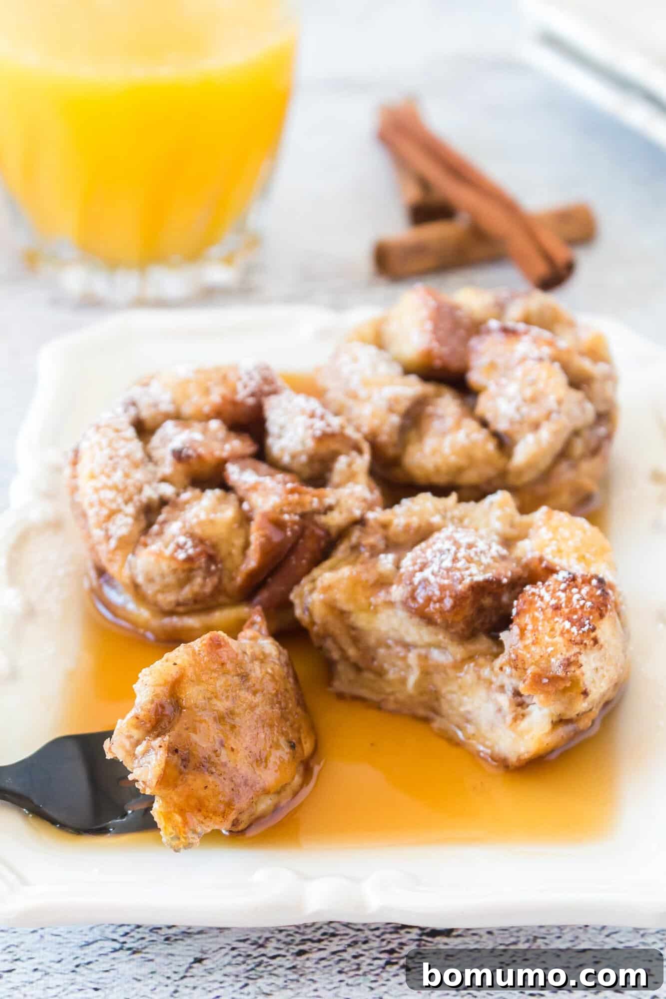 A French toast muffin, sliced open to reveal its tender, custardy interior and slightly crispy edges.