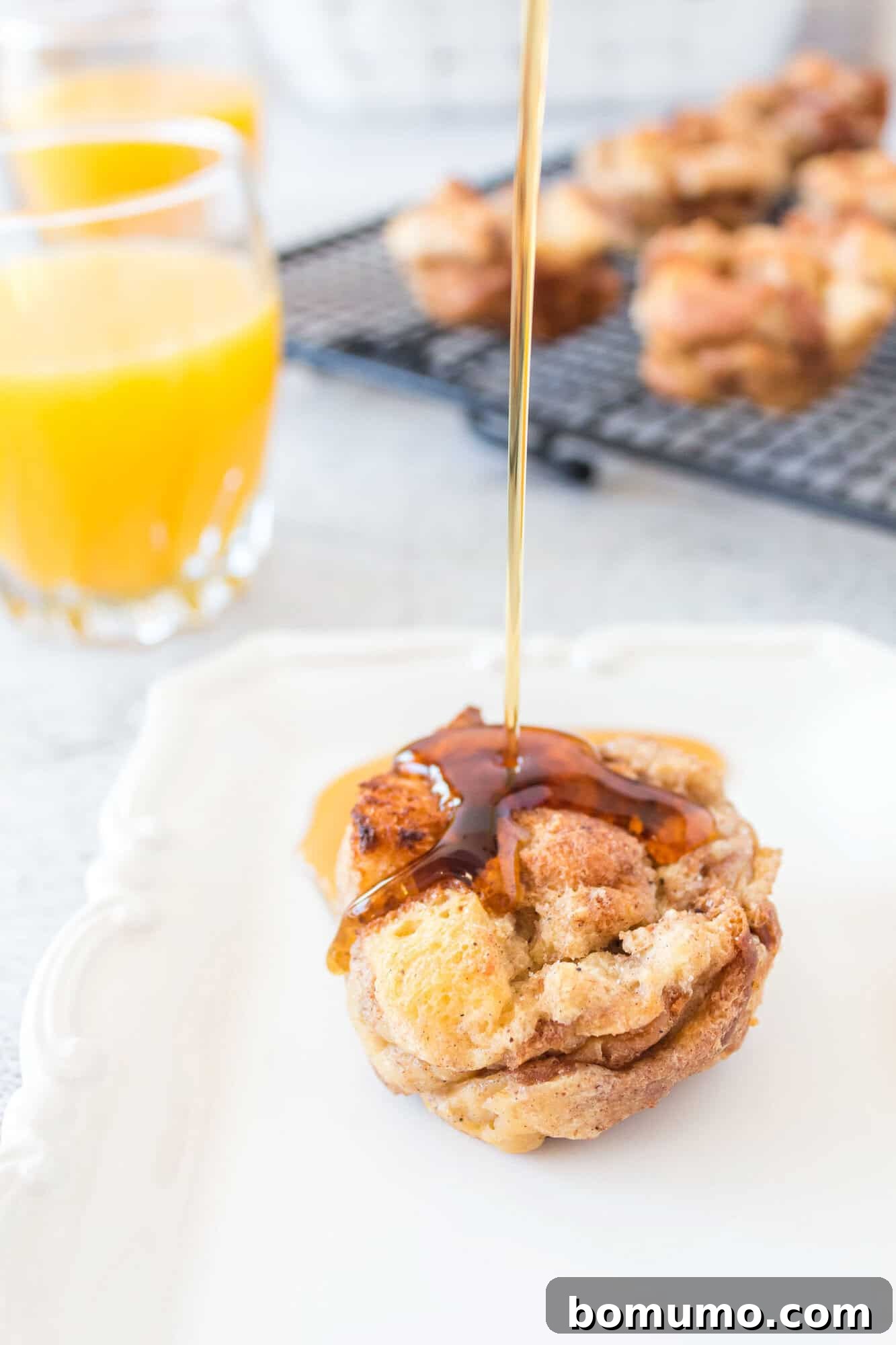 Golden syrup gracefully drizzling over a perfectly baked French toast muffin, highlighting its rich, moist texture.