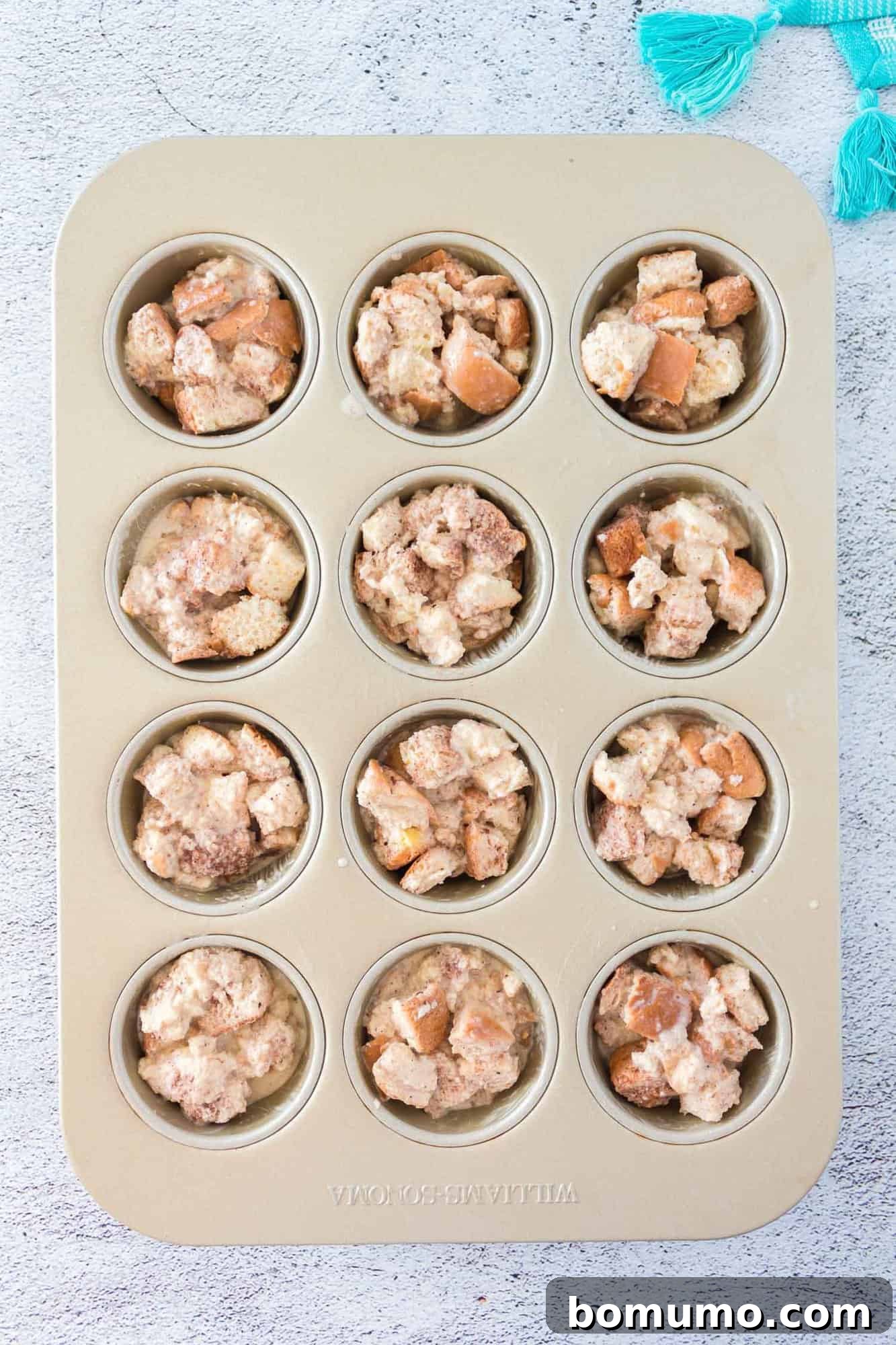 The muffin tin filled with the unbaked French toast mixture, ready for the oven.