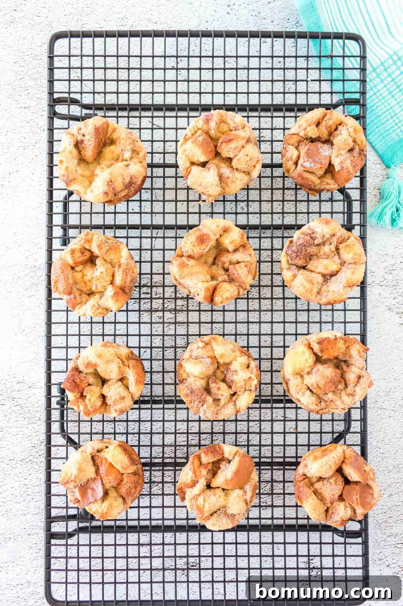A batch of baked French toast muffins cooling on a wire rack, ready to be served.