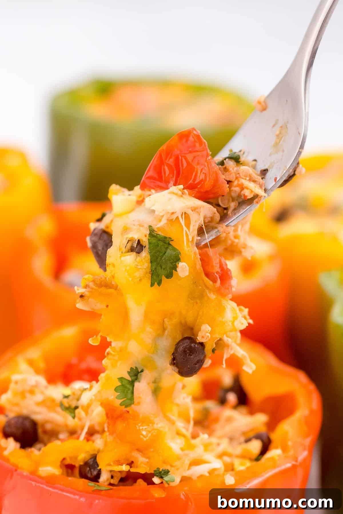 A close-up shot of a fork expertly scooping out the delicious, cheesy, and vibrant filling from a baked Southwestern stuffed bell pepper, highlighting the textures and ingredients.