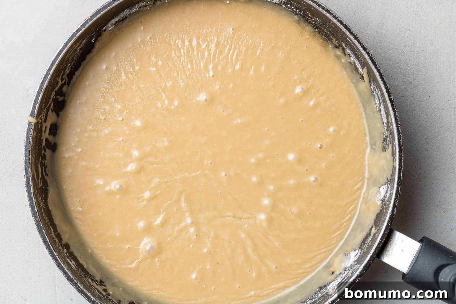 Close-up of the brown sugar glaze in a saucepan, ready for dipping.