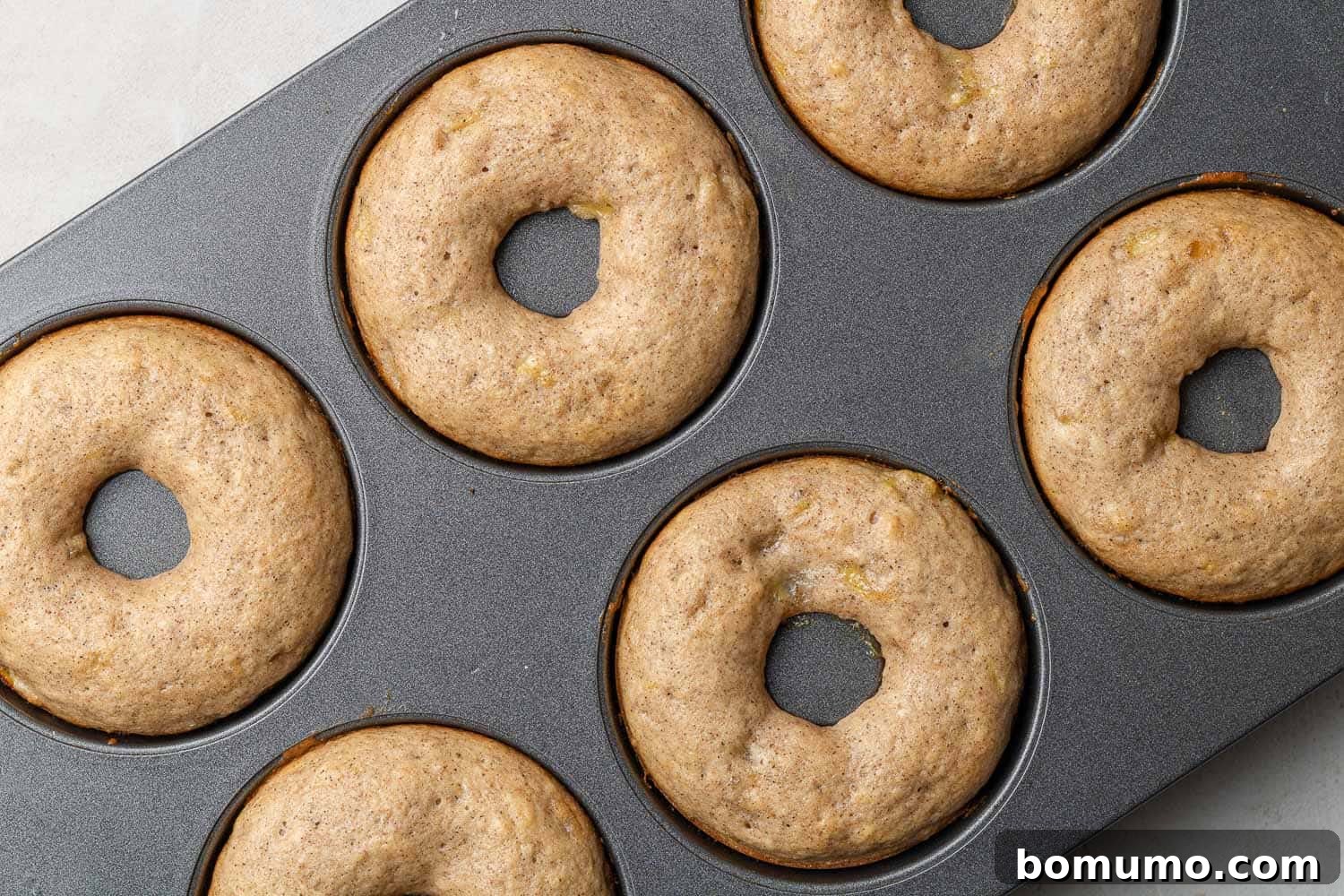 Baked donuts in the donut pan, fresh from the oven, ready for glazing.