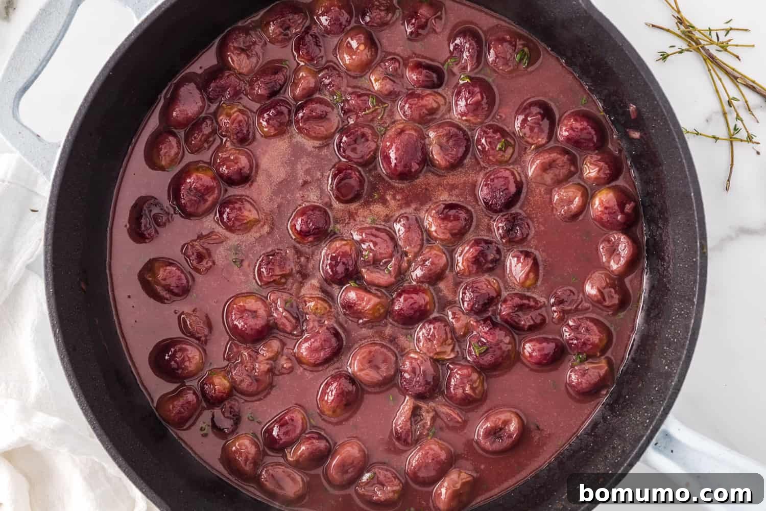 The rich and glossy port wine sauce, perfectly thickened with roasted grapes, simmering in the skillet.