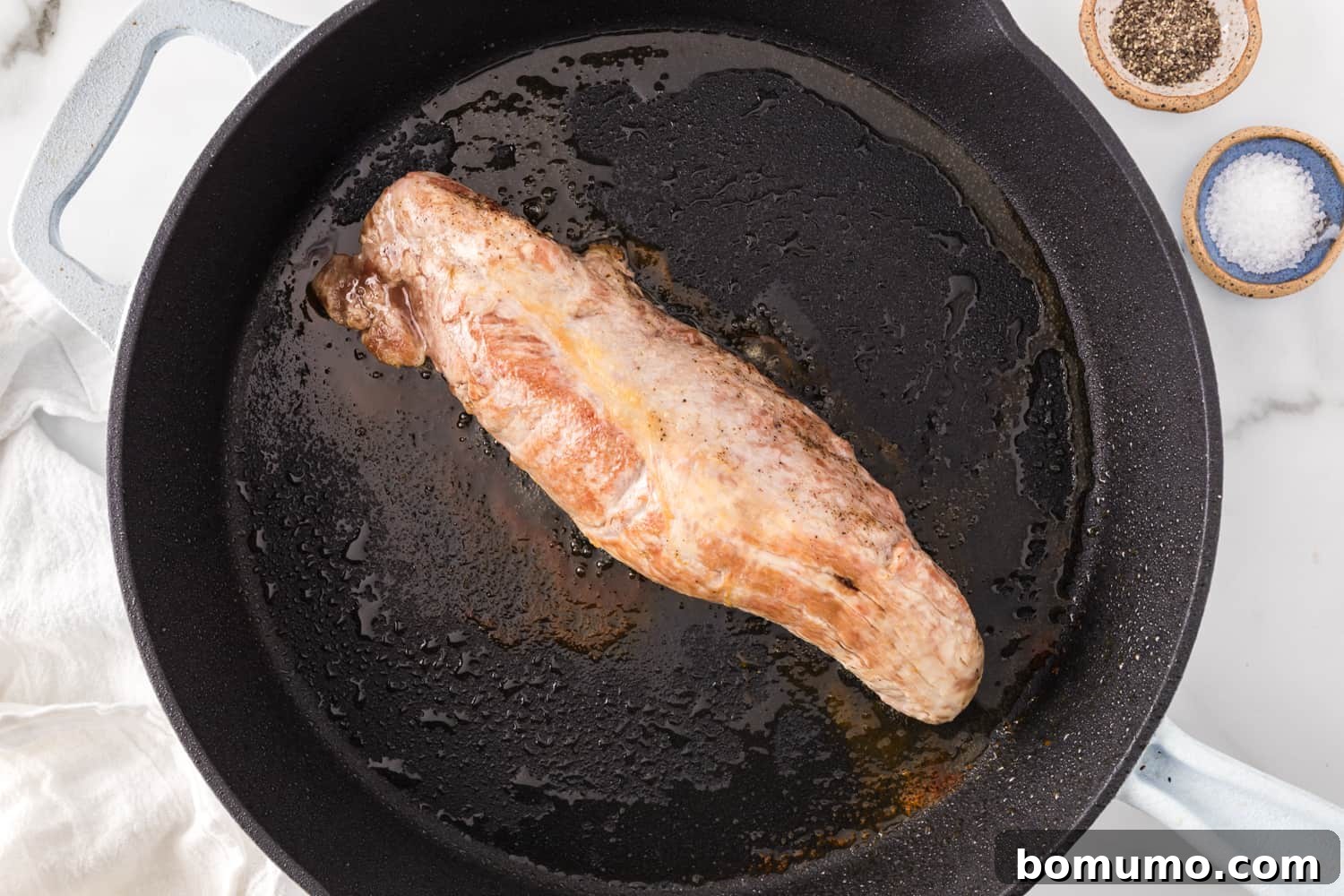 Pork tenderloin, beautifully browned on one side from searing, now ready to be transferred to the oven.
